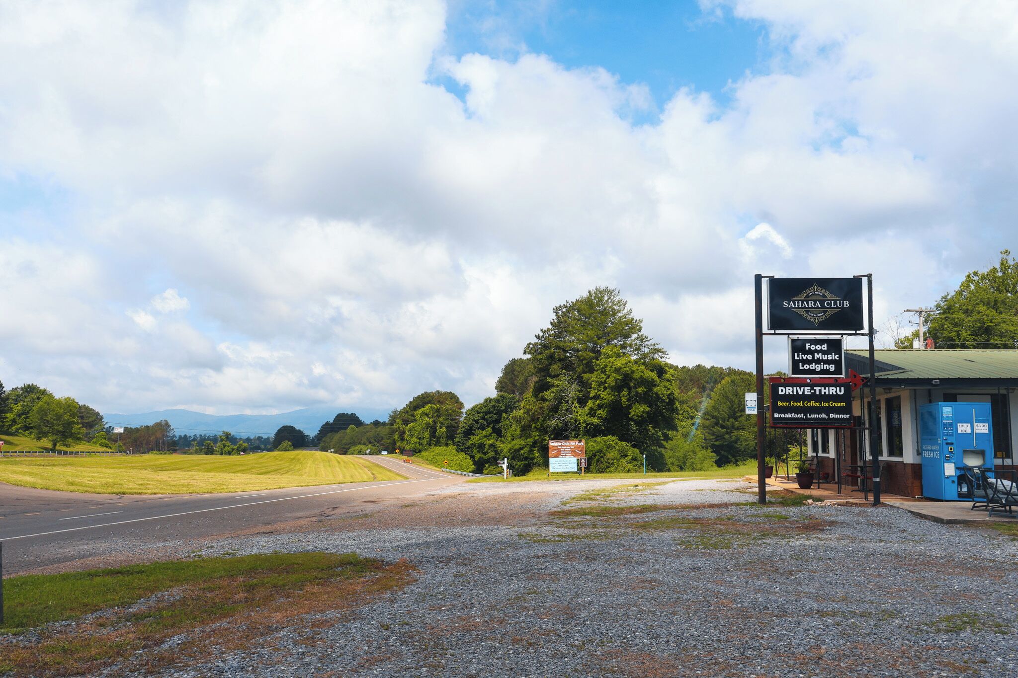A drive-thru area with a sign for Sahara Club, indicating food, live music, and lodging services.