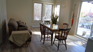 A living room with a sofa, a dining table with chairs, and a potted plant. - Creativity Spa Studio, be inspired, rejuvenated & relaxed, Heaven on Earth! (Bracebridge)