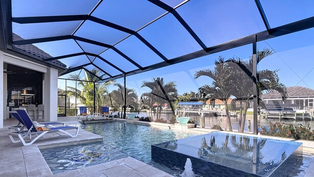 Un espace piscine avec des chaises longues, un jacuzzi et une terrasse couverte.