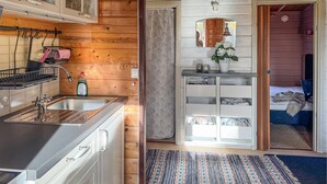 A compact kitchen with wooden walls, a sink, and a small countertop. - Gorgeous home in Rörvik with WiFi (Rörvik)