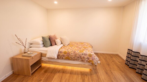 Une chambre à coucher avec un lit, une table de chevet et une commode.