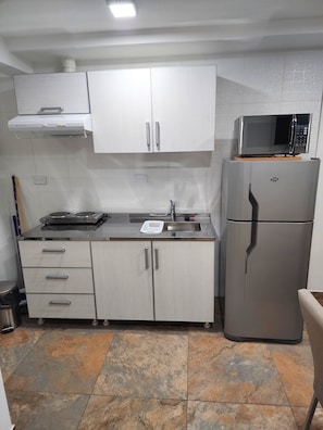 Comfort appartement | Privékeuken | Een minikoelkast, een microgolfoven, kookgerei, borden en bestek