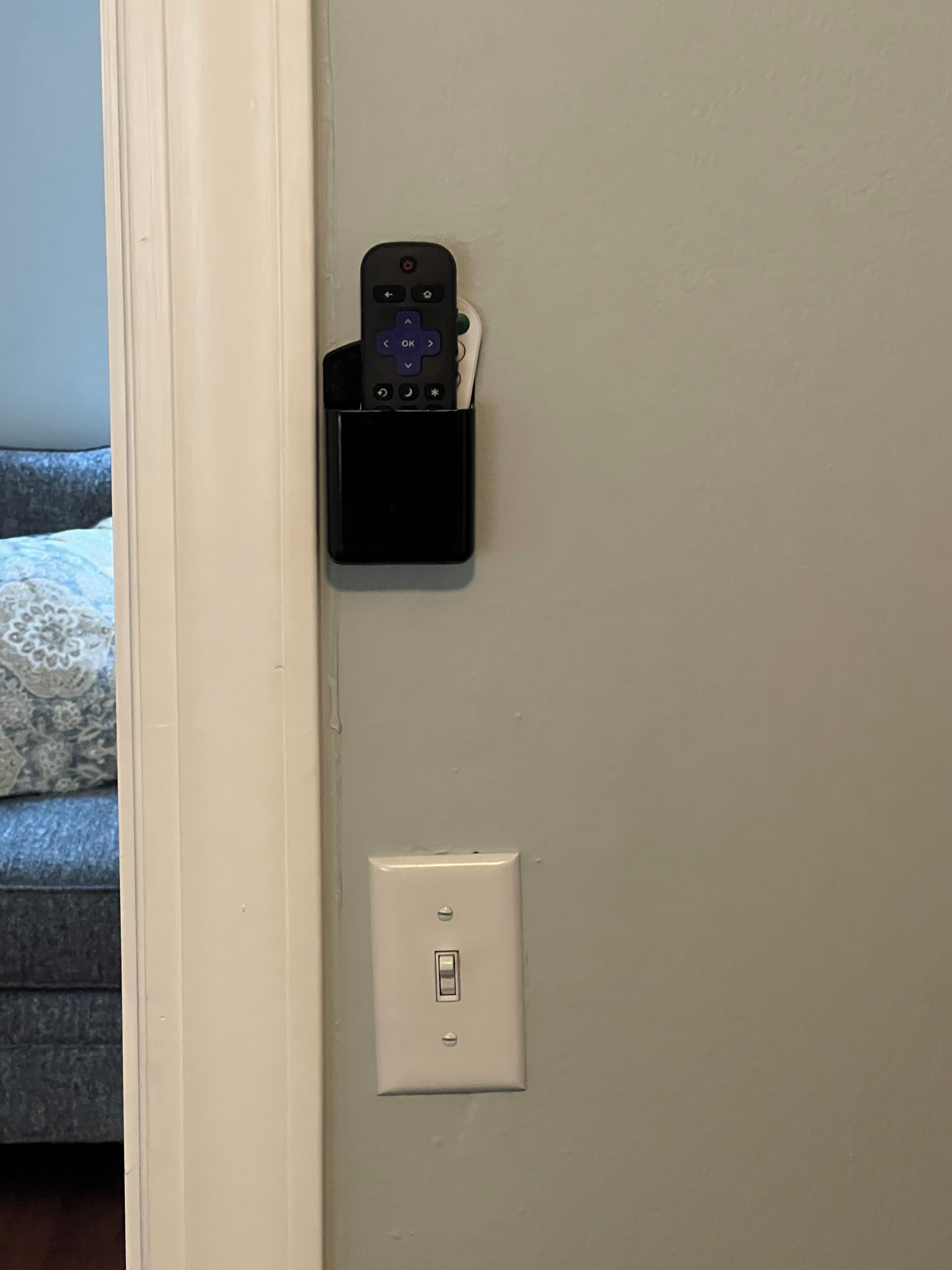 A wall-mounted charging station with a remote control and a power outlet.