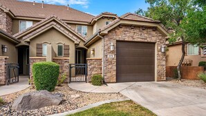 A two-story house with a stone facade, a garage, and a well-maintained front yard. - Coral Ridge 4174, Outdoor seating, grill, community amenities (Washington)