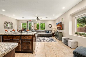 A spacious living area with a kitchen island, a sofa, and a dining table.