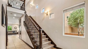 A staircase with a wooden handrail and black balusters, leading to a second floor. - Coral Ridge 4174, Outdoor seating, grill, community amenities (Washington)