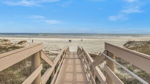 A wooden boardwalk leading to a beach with a clear sky. - Drift Away in our cozy coastal retreat in St. Augustine Beach! (St. Augustine)