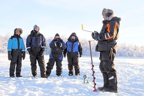 A group of people in winter clothing standing in a snowy outdoor area. - Inari Hotel (Inari)