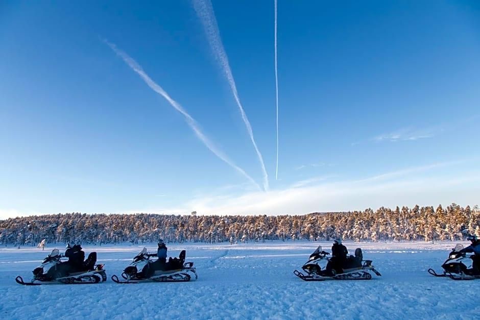 Un grupo de motos de nieve en un paisaje nevado con cielo despejado.