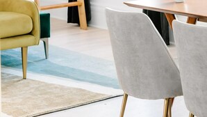 Une chambre de dortoir avec un lit superposé, une échelle en bois, une table avec une tasse blanche et des chaises modernes.