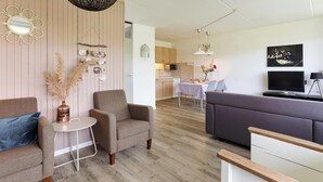 Un salon moderne avec un canapé, un fauteuil et une table à manger.