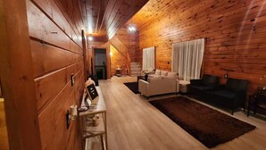 A cozy wooden interior with a sofa, a coffee table, and a fireplace. - Cozy getaway in Brighton (Brighton)