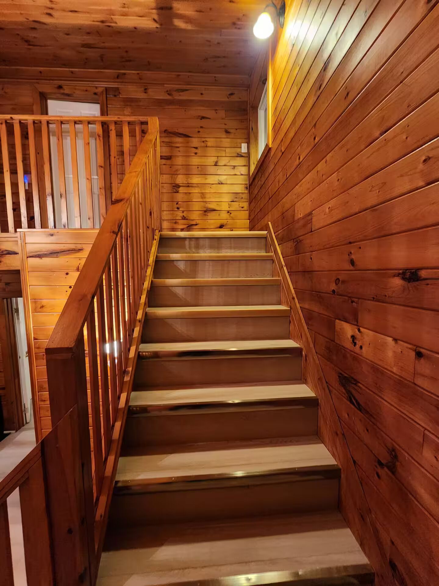 Un escalier en bois, doté d’une rampe, menant à l’étage supérieur.