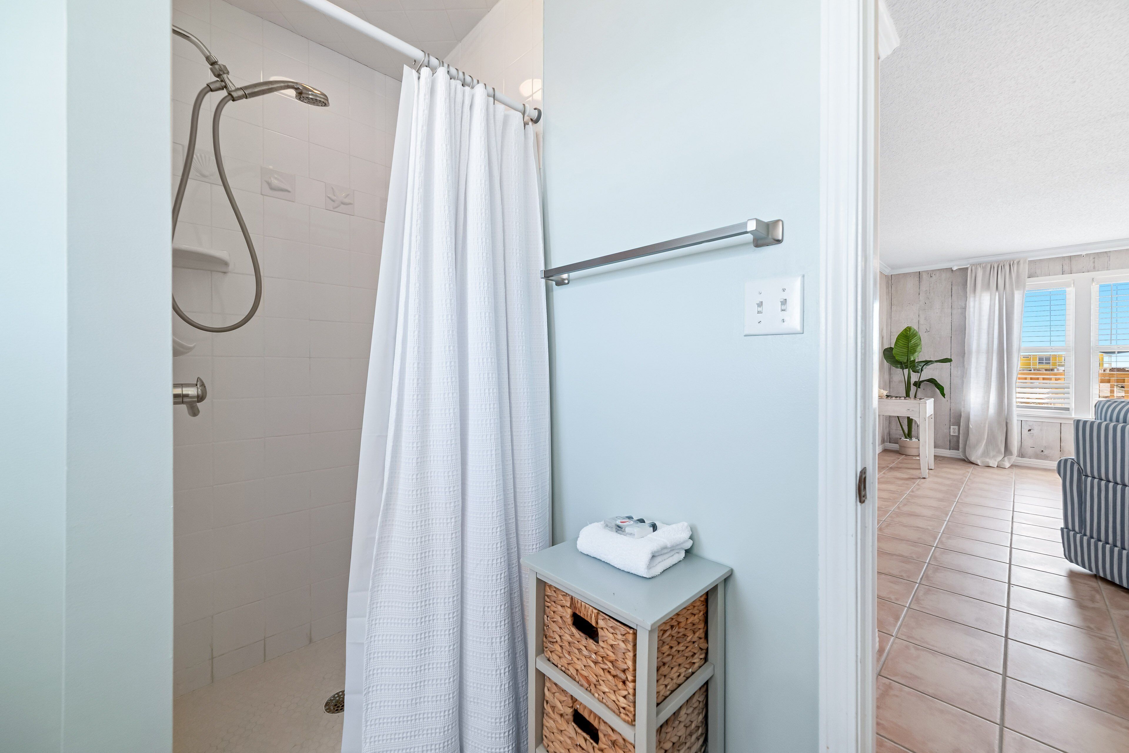 Ein Badezimmer mit Dusche, Handtuchhalter und einer kleinen Ablagefläche.