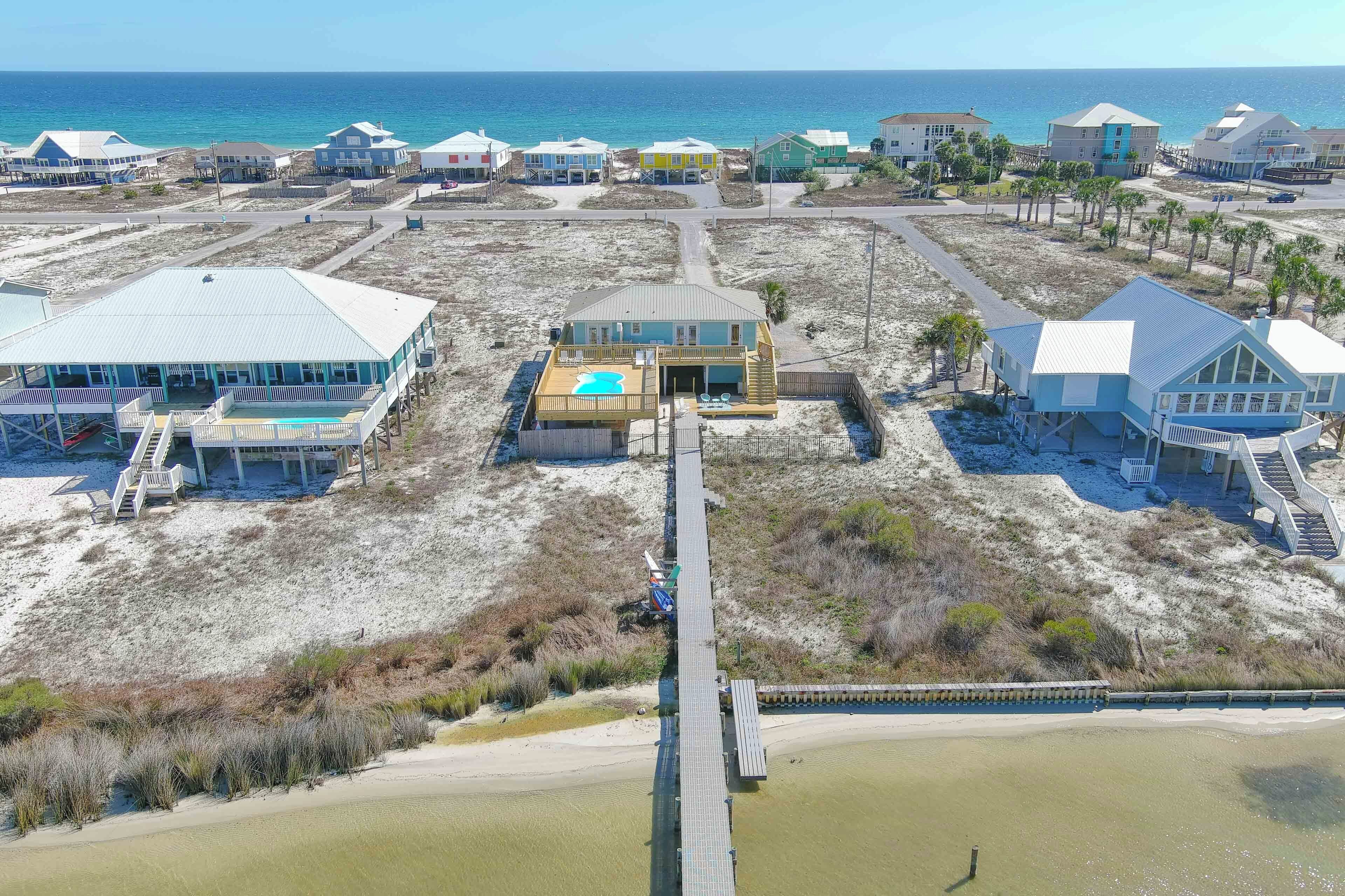 Una propiedad costera con varias construcciones, un muelle y una playa.