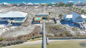 Une propriété située sur la côte, comprenant plusieurs bâtiments, un quai et une plage.