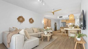 En moderne stue med sofa, sofabord og spiseplads.