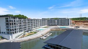 Un hotel moderno con varios pisos, piscina y zona de embarque.