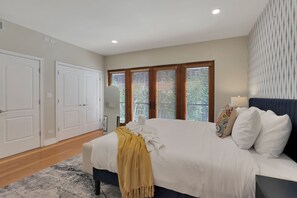 A bedroom with a large bed, a wardrobe, and a window with blinds. - Stylish 3BR Townhouse with 2 Jacuzzi  and 1 private garage spot (Chicago)