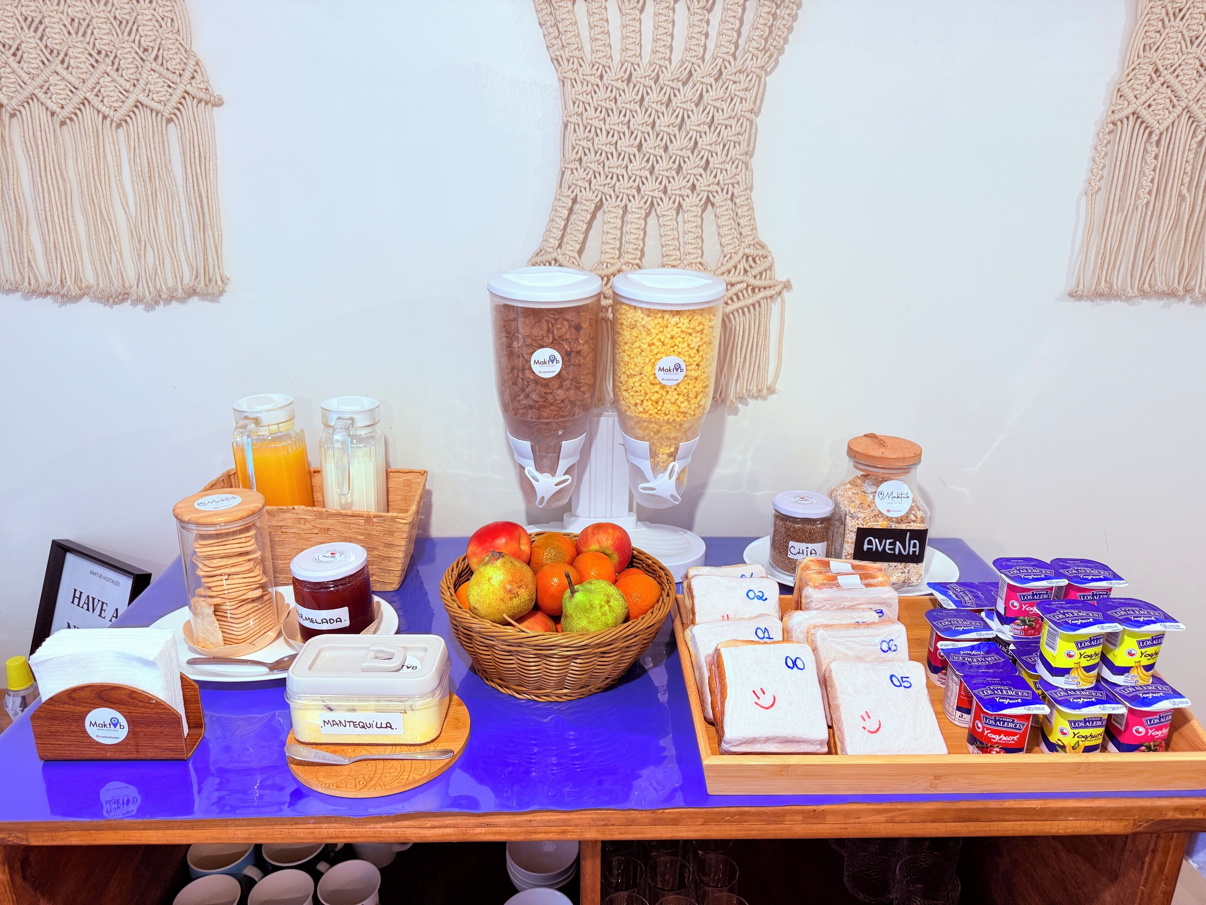 A breakfast buffet with various food items, including fruits, bread, and dairy products.