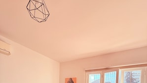 A bedroom with a bed, a window, and a painting on the wall. - Maktvb Europa Hostal Boutique (Santiago)