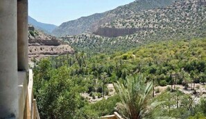 A view of a mountainous landscape with sparse vegetation and a clear sky. - Gite jawaher aguerd (Aqesri)