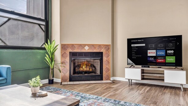 A modern living room with a fireplace, a flat-screen TV, and a coffee table.