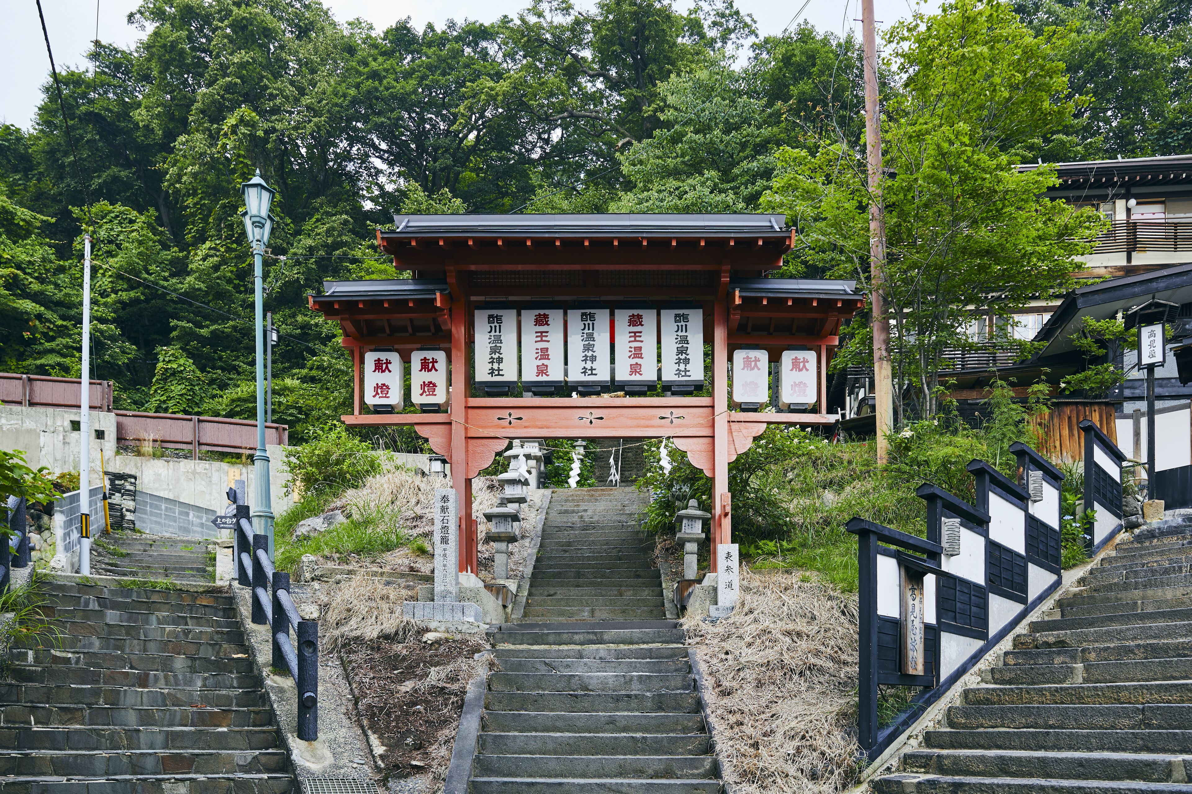 Ein traditionelles japanisches Tor mit steinernen Stufen, die davor hinaufführen.