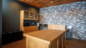A modern kitchen with a wooden ceiling, a stone backsplash, and a wooden bar counter. - YuiLocalZao (Yamagata)