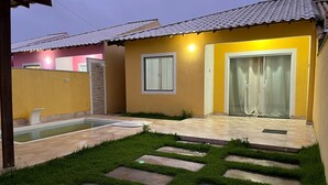 Une propriété résidentielle dotée d’une piscine, d’un patio couvert et d’une pelouse bien entretenue.