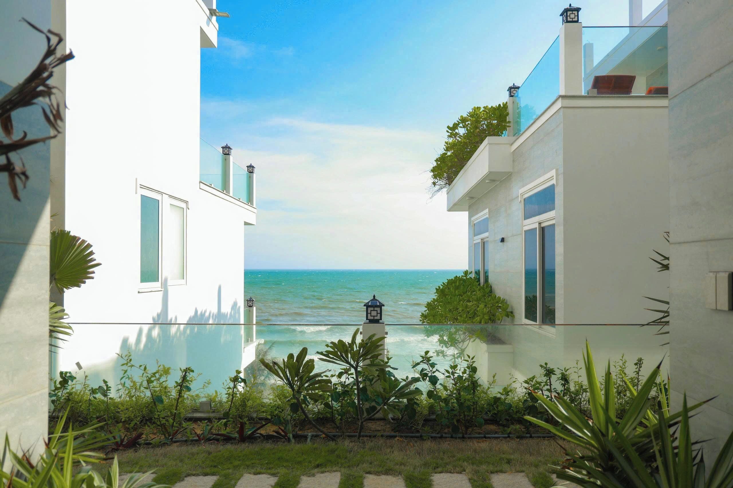 A modern building with a glass balcony overlooking a body of water.