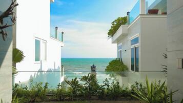 A modern building with a glass balcony overlooking a body of water.