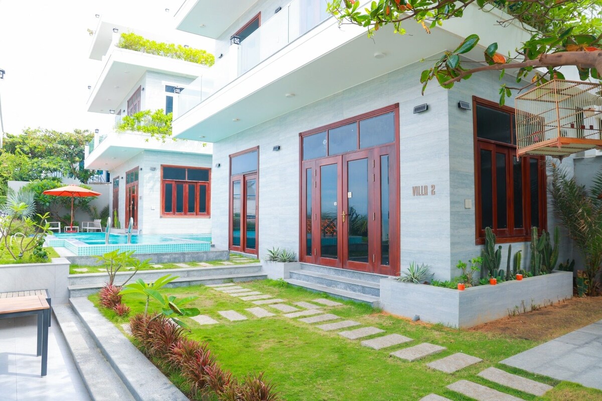 A modern villa with a swimming pool, large windows, and a well-maintained garden.