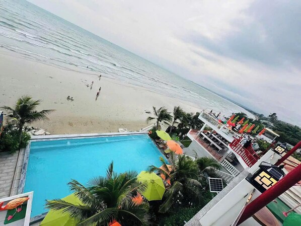 A poolside view with a beach and ocean in the background. - BayView Resort & Villas (Mui Ne)