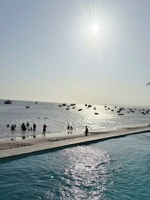 A beach with boats, people, and a clear sky. - BayView Resort & Villas (Phan Thiet)
