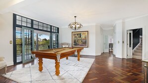 A spacious room with a pool table, a chandelier, and a large painting. - Southern Grace - the perfect Southern Highlands escape, spacious, stylish and serene (Bowral)