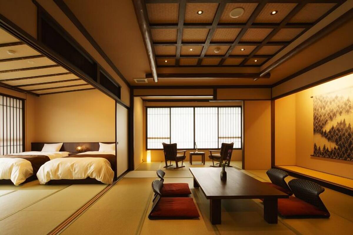 A traditional Japanese room with tatami flooring, a low table, and a sofa.