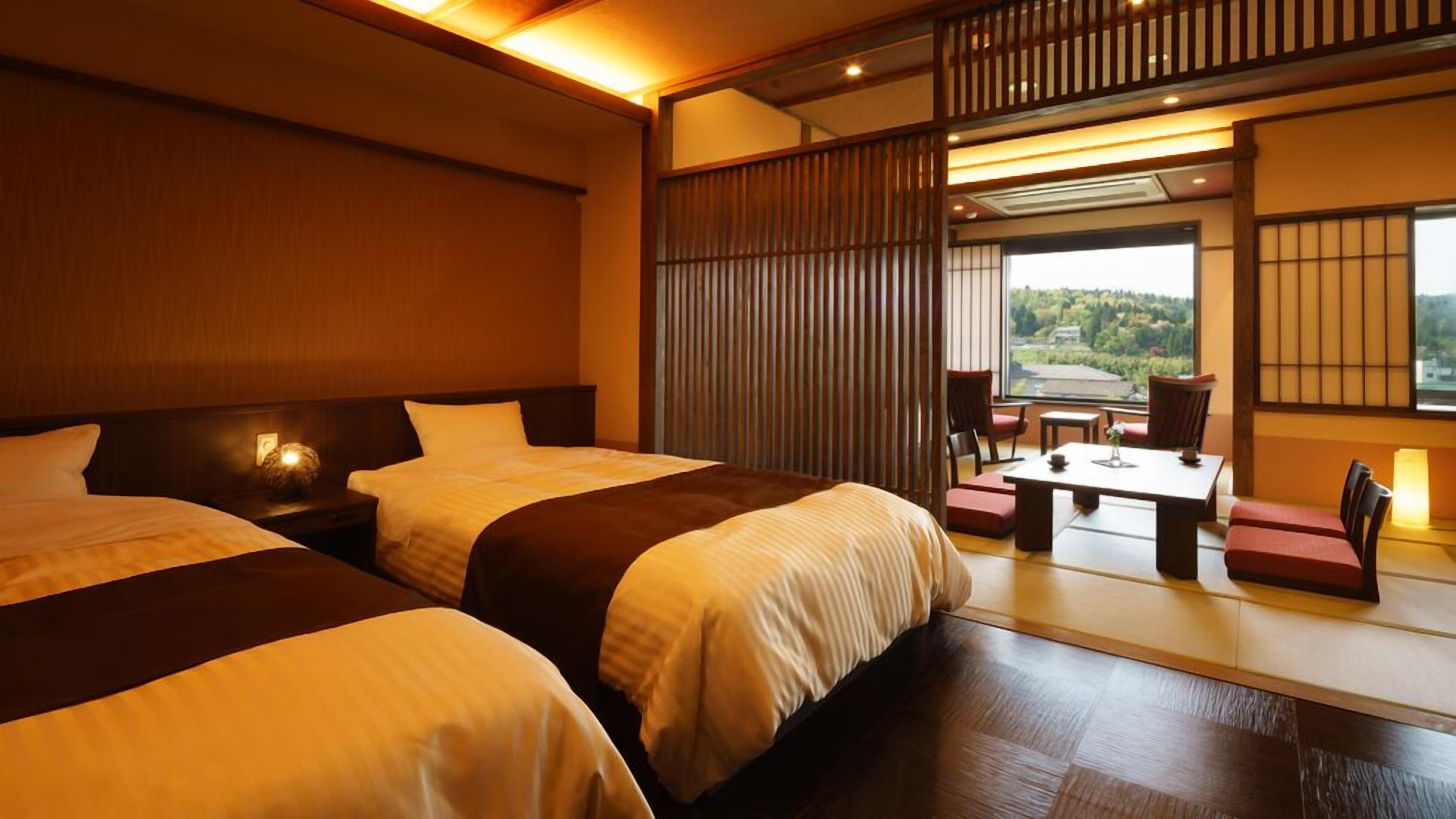 A hotel room with two beds, a sitting area with a table and chairs, and a view of the outdoors.