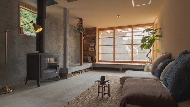 A living room with a fireplace, a sofa, a coffee table, and a bookshelf. - La Toile (Mitoyo)