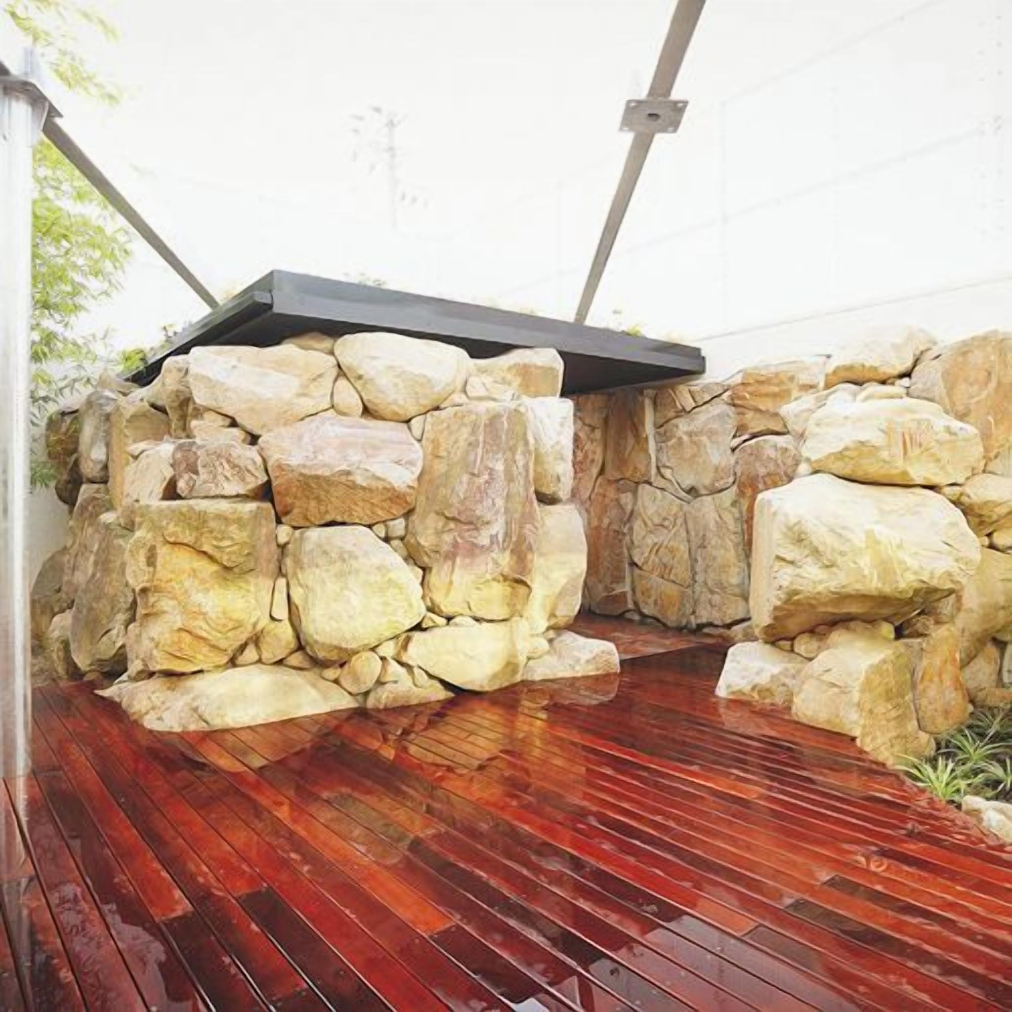 A stone wall with a wooden deck.