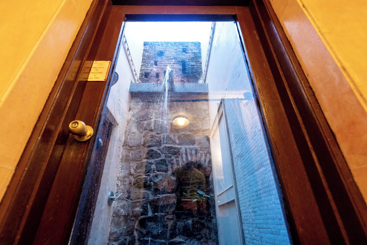 A narrow stone staircase leading to a door with a brass doorknob.