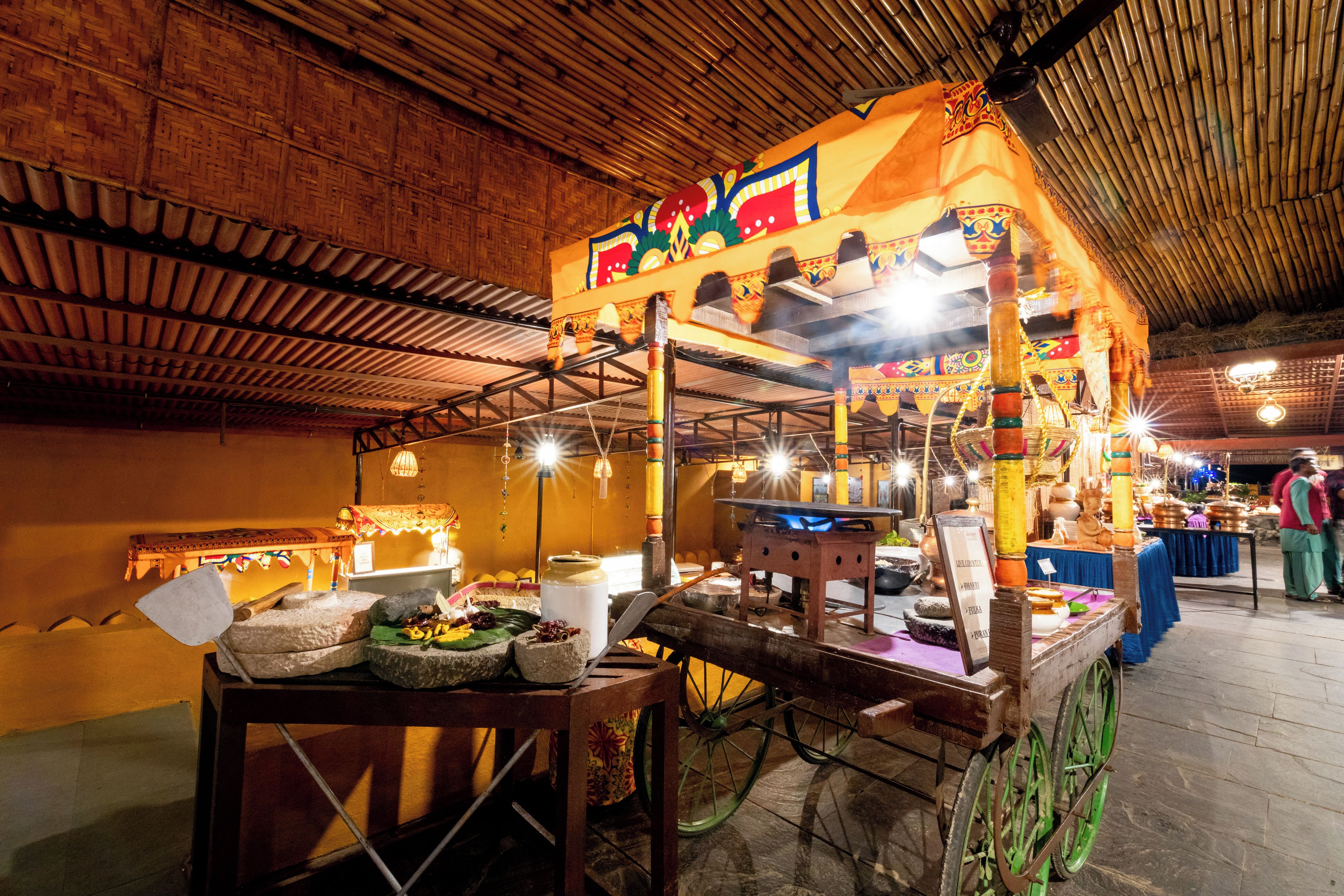 A traditional market stall with a wooden cart, various goods, and a decorative canopy.