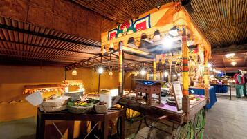 A traditional market stall with a wooden cart, various goods, and a decorative canopy.