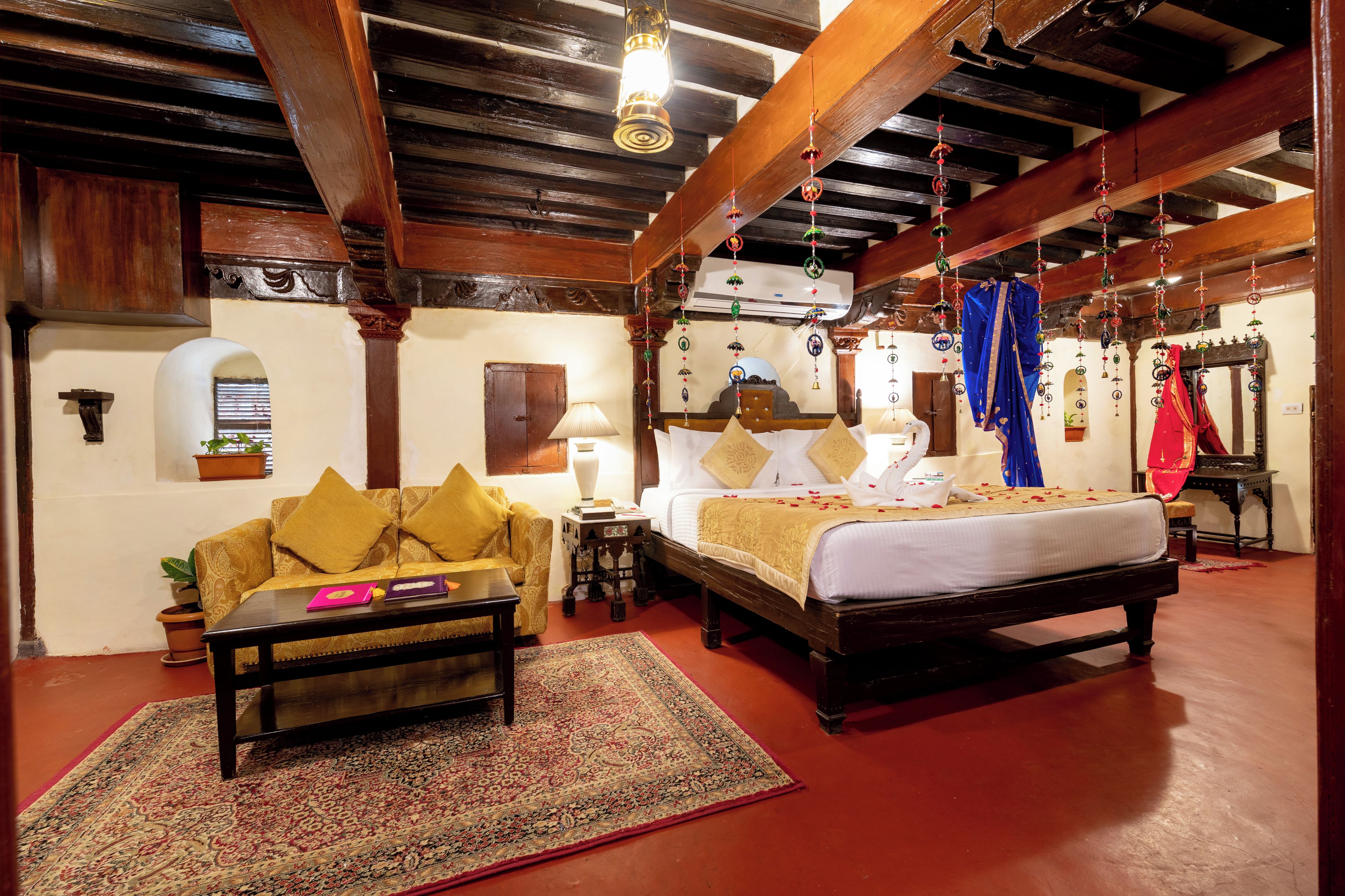 A traditional room with a bed, sofa, and a small table with a rug.