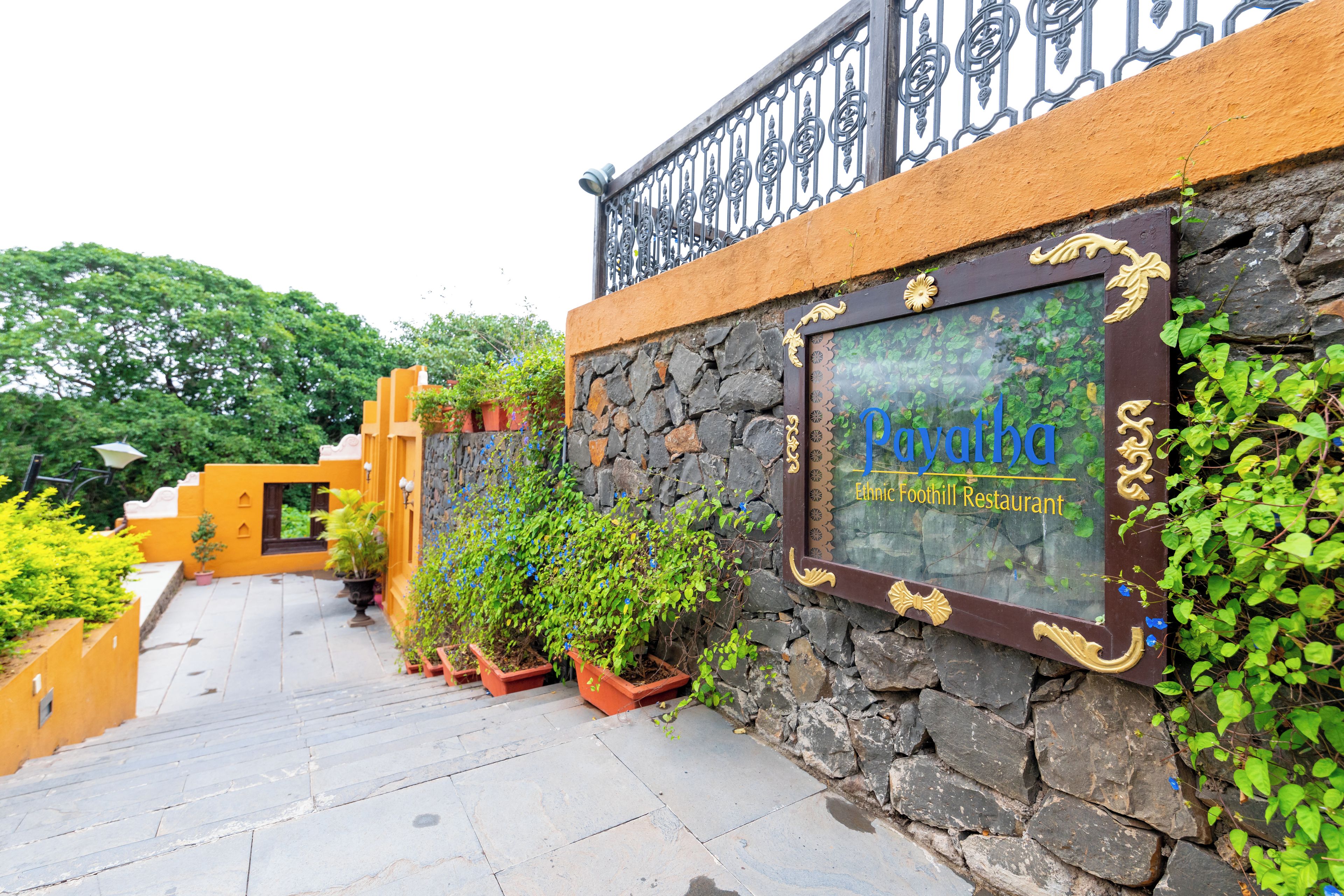 A stone wall with a sign for Ethnic Foothill Restaurant.