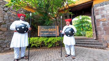 Two individuals in traditional attire holding shields, standing in front of a sign that reads "Kurt Jaldhay GAPH."
