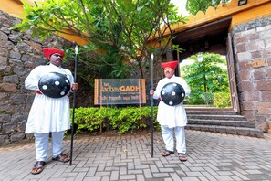 Two individuals in traditional attire holding shields, standing in front of a sign that reads "Kurt Jaldhay GAPH." - Fort Jadhavgadh (Sasvad)