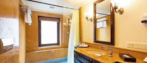 Un baño con un espejo grande, un lavamanos, una ducha con puerta de cristal y un perchero para toallas.