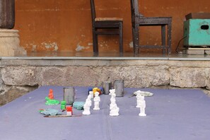 A table with various items including small statues, paint bottles, and metal containers. - Fort Jadhavgadh (Sasvad)