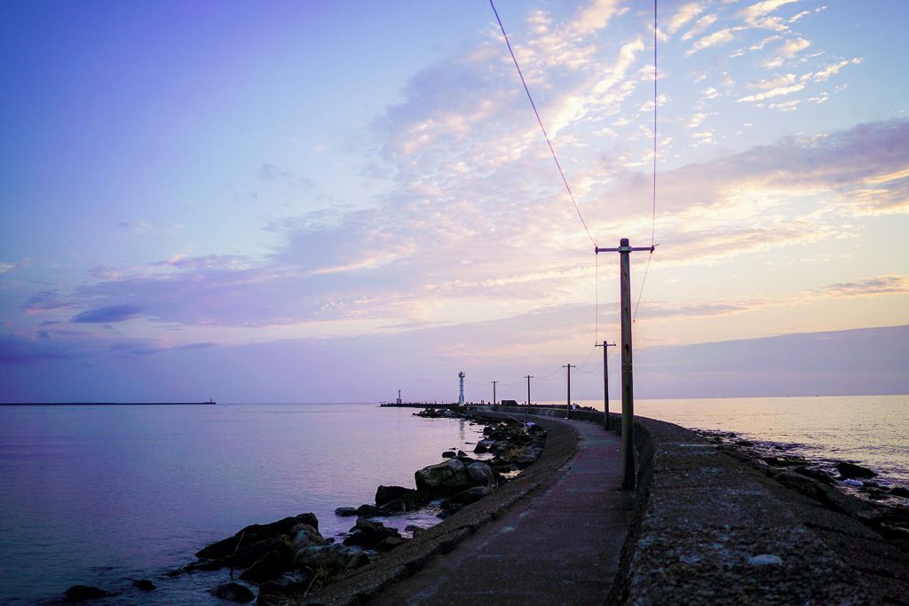 Un paseo marítimo con cielo despejado y mar tranquilo.